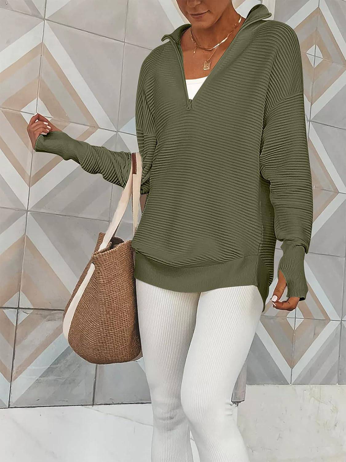 a woman wearing white pants and a green sweater