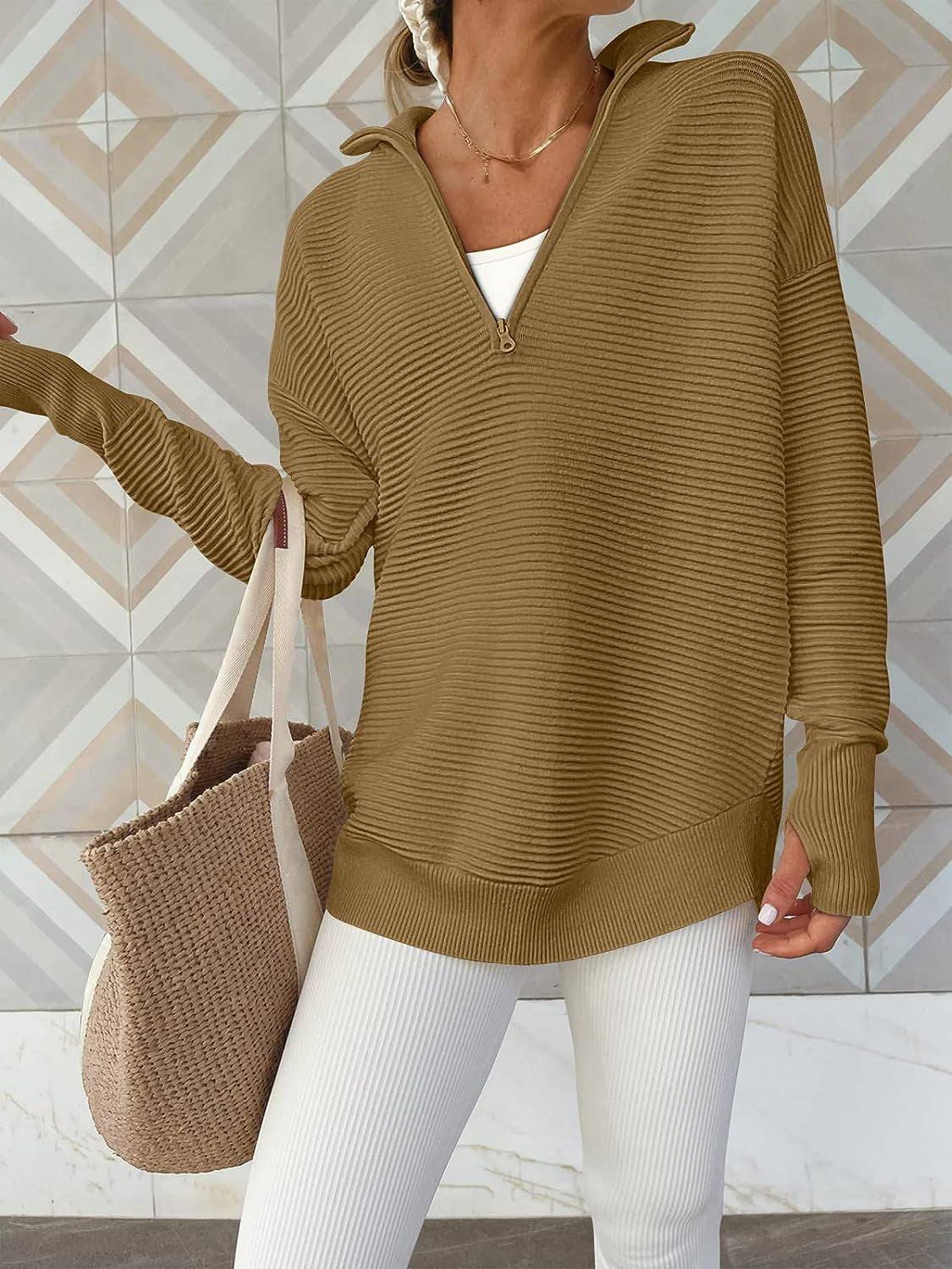 a woman wearing a brown sweater and white pants