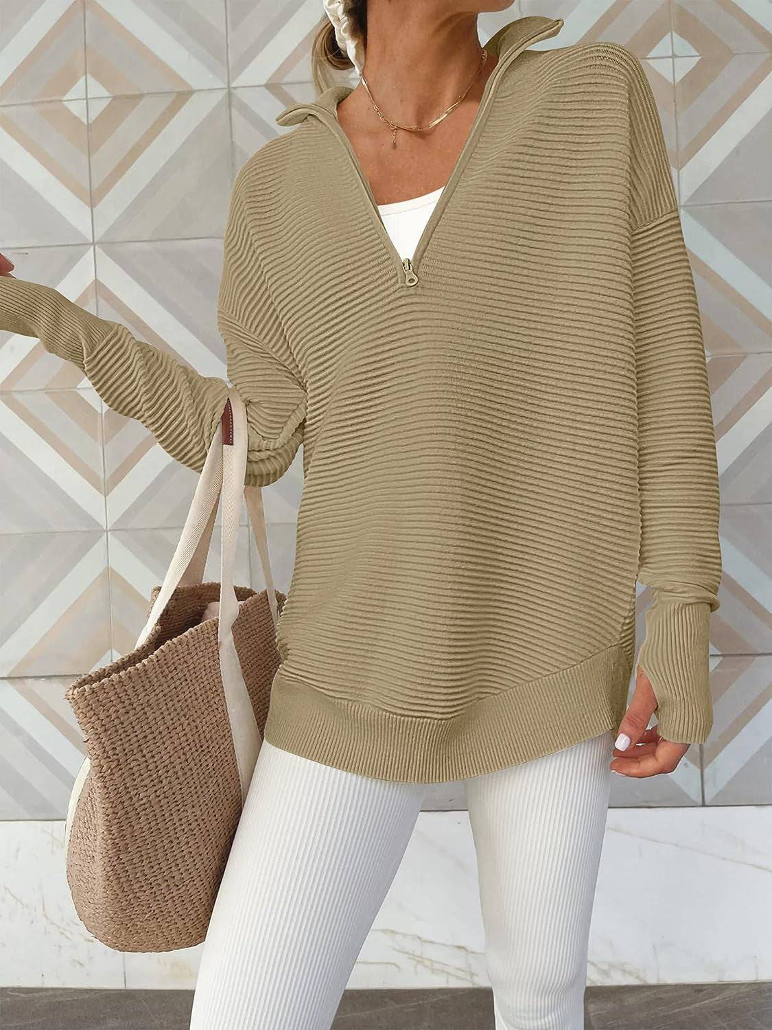 a woman wearing a tan sweater and white pants