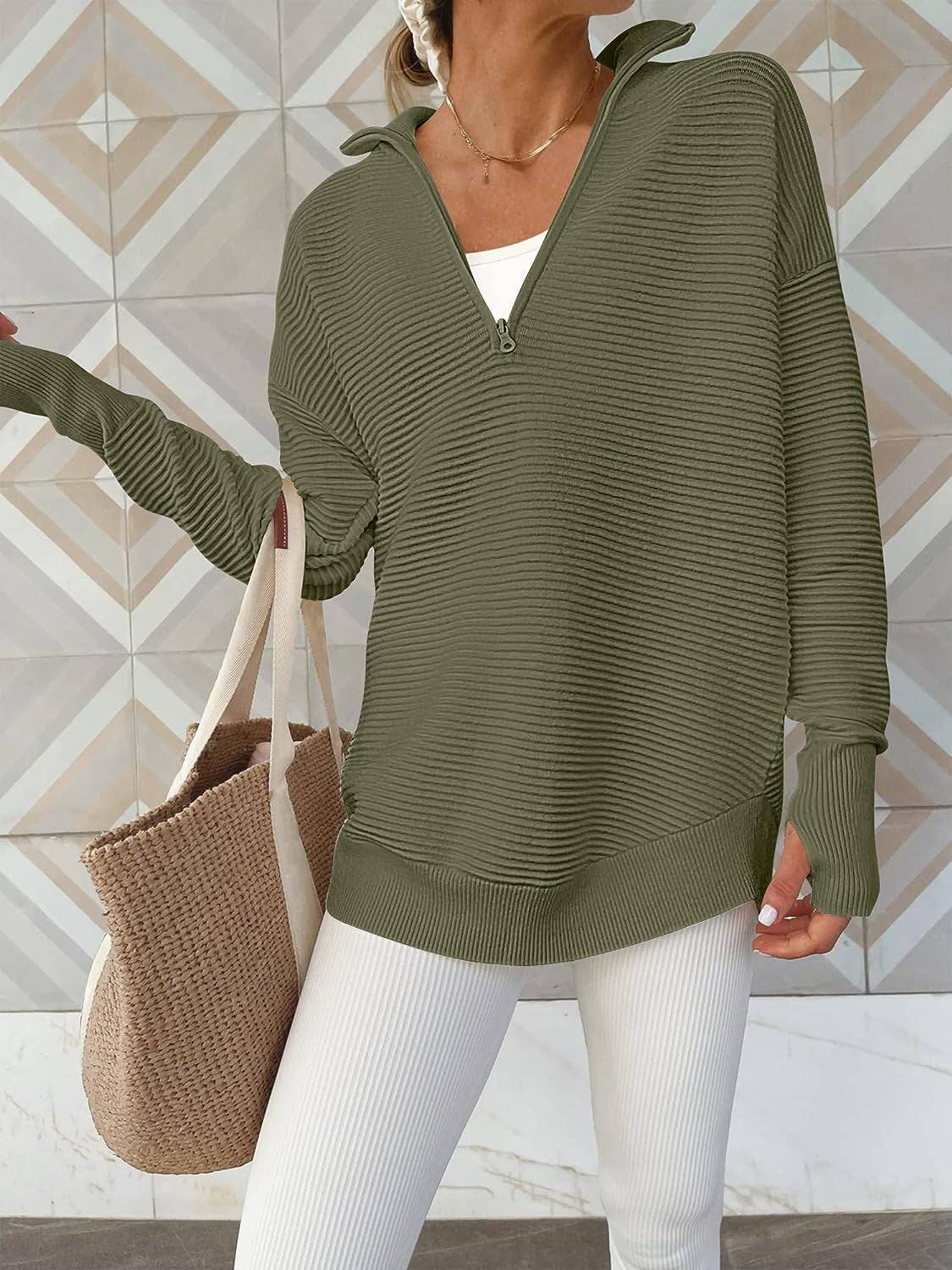 a woman wearing a green sweater and white pants