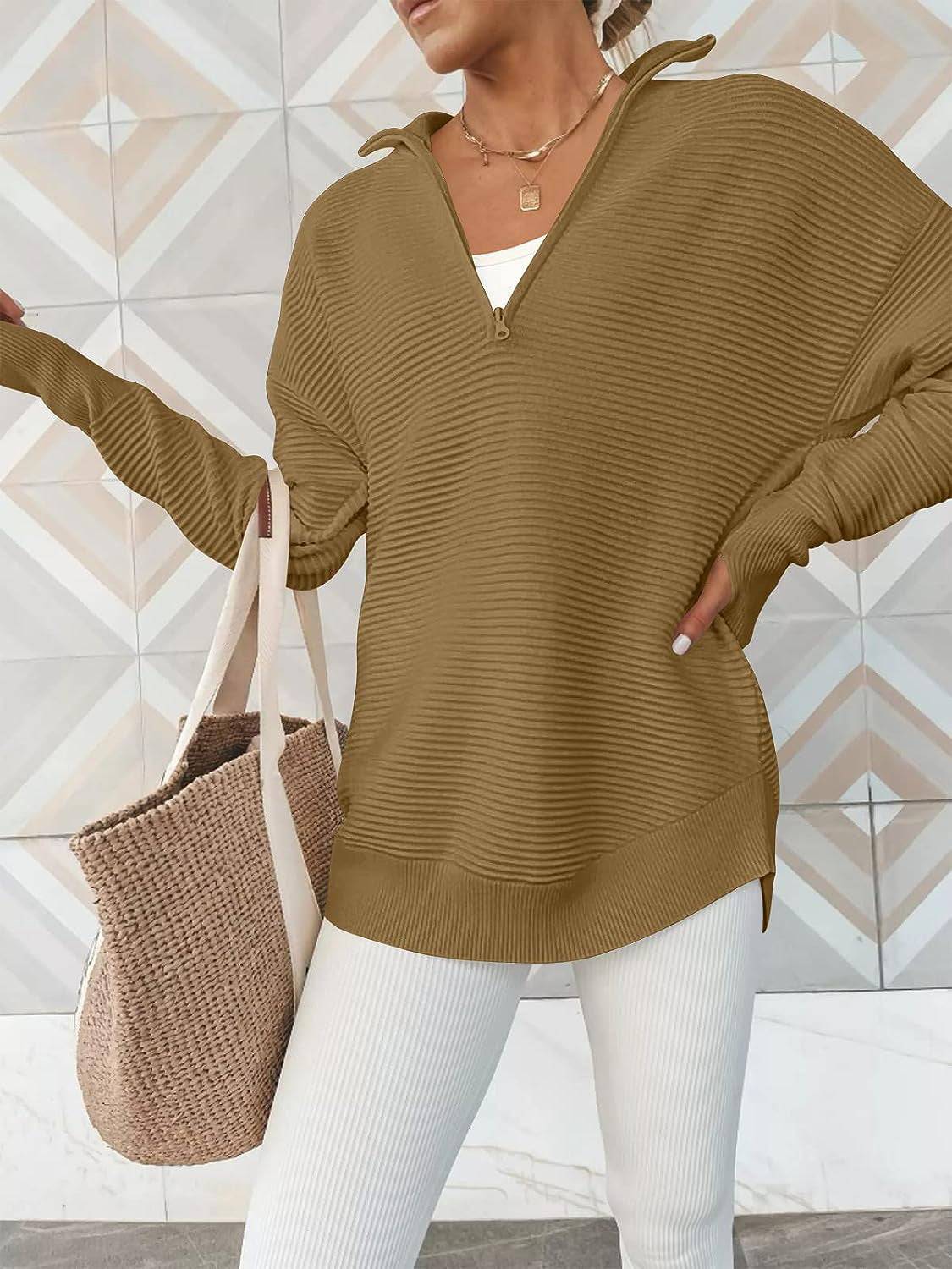 a woman wearing a brown sweater and white pants