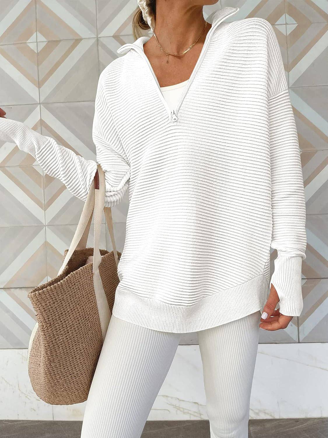 a woman wearing a white sweater and white pants