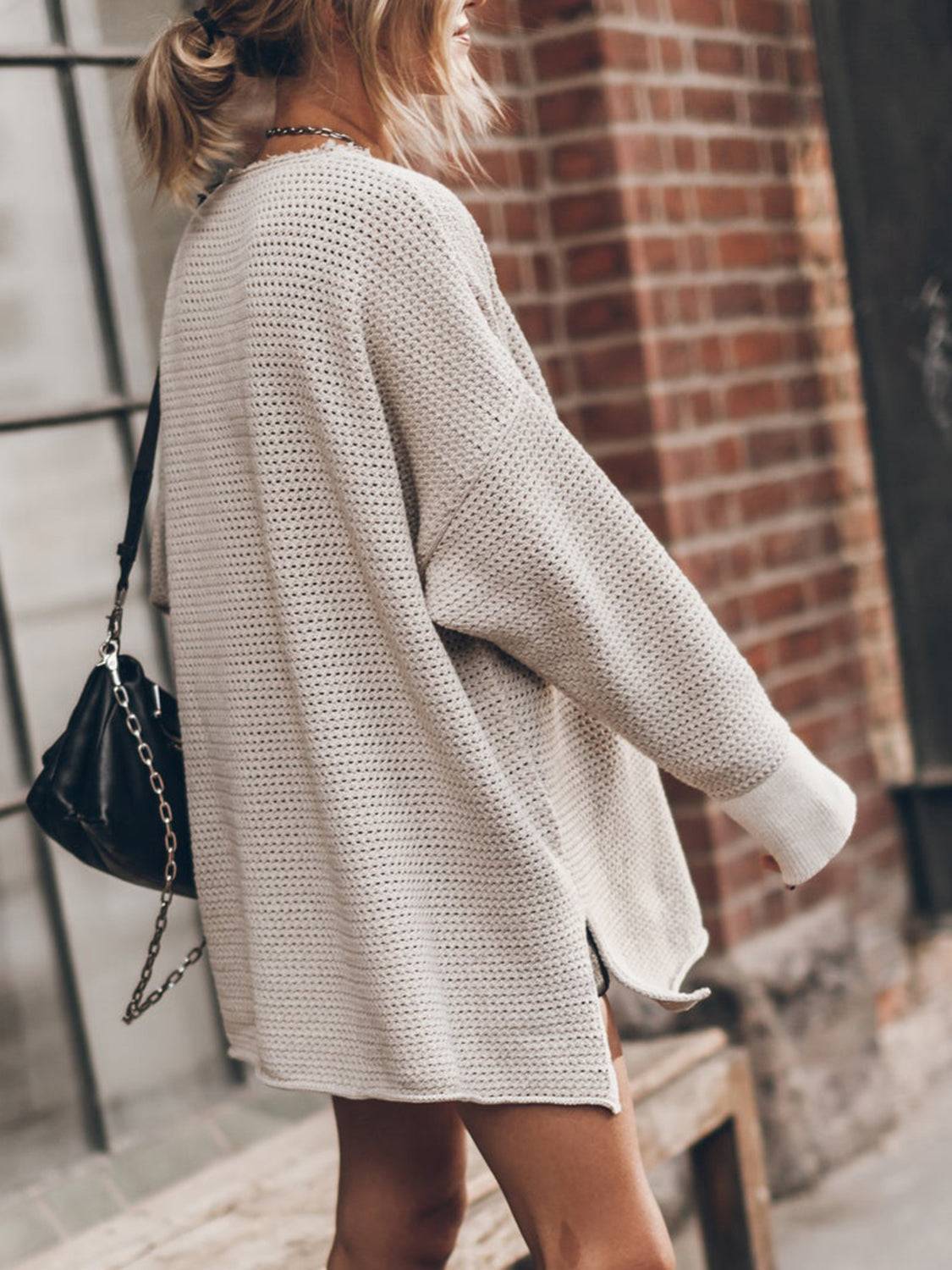 a woman walking down the street wearing a white sweater