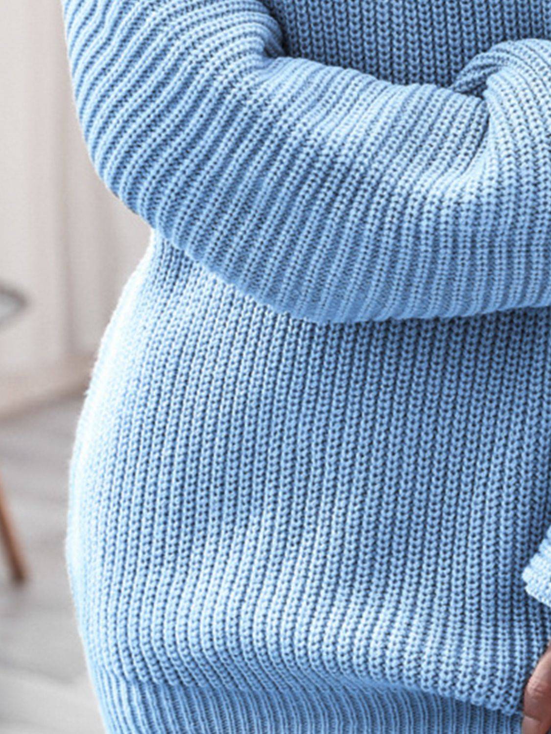 a woman in a blue sweater holding her stomach