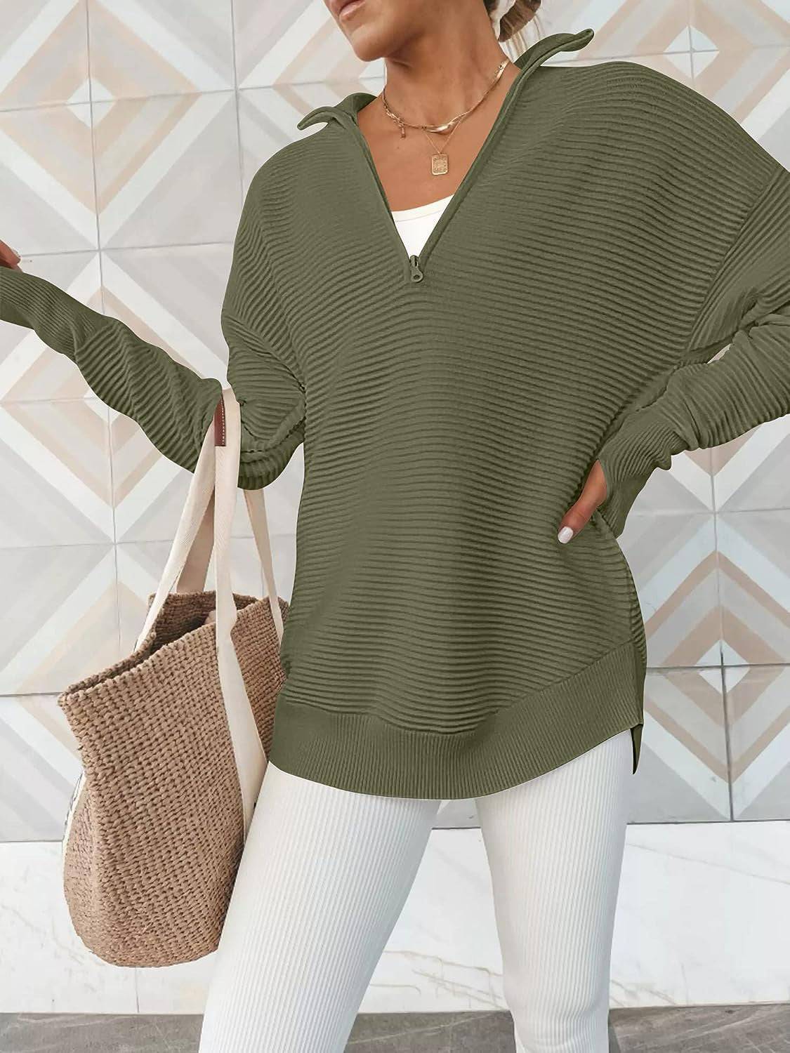 a woman wearing a green sweater and white pants