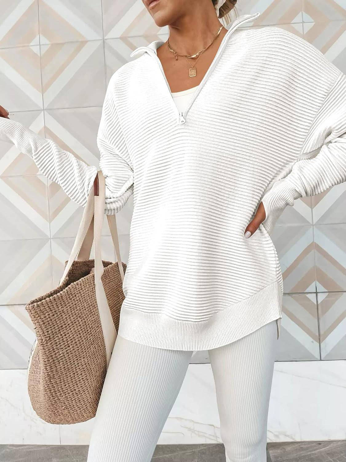 a woman wearing a white sweater and white pants