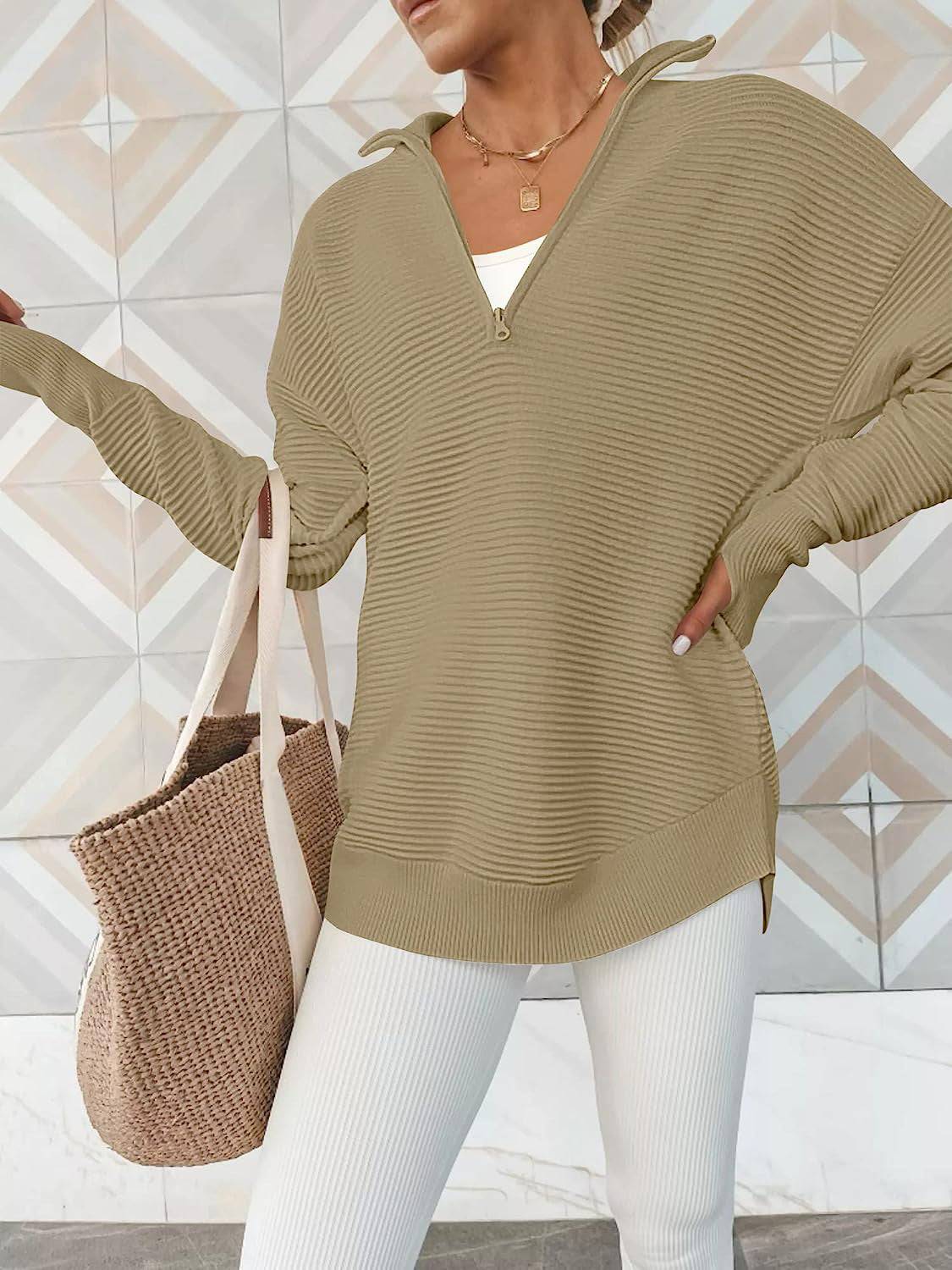 a woman wearing a tan sweater and white pants