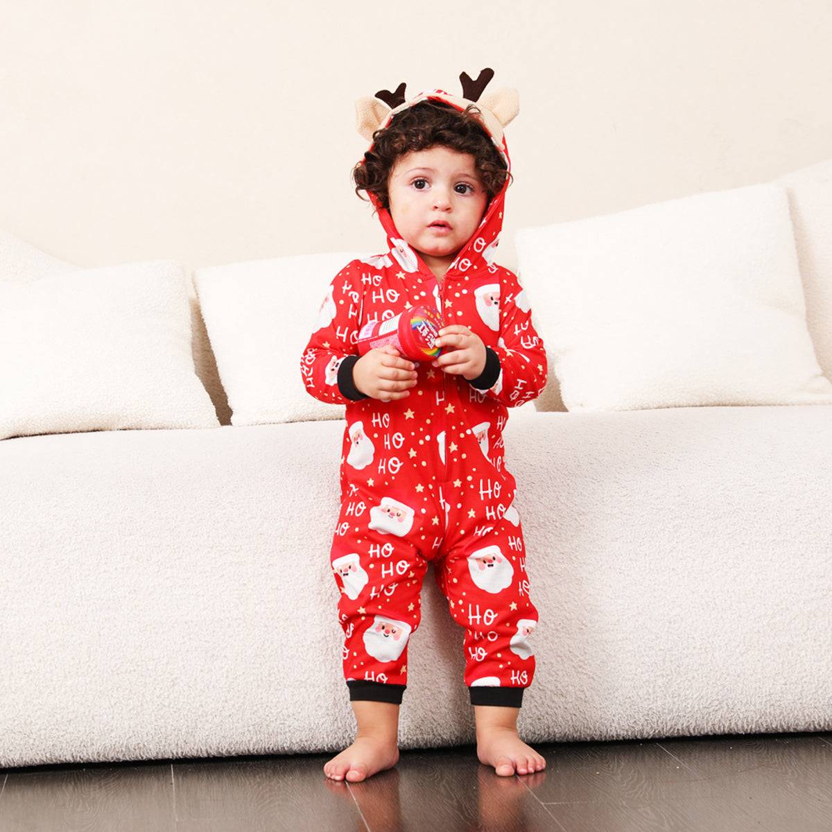 a little boy wearing a red christmas pajamas